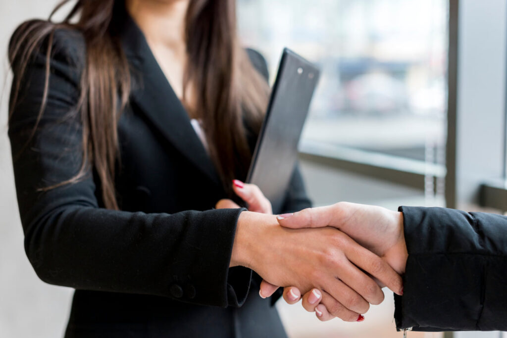 Mujer con traje dadno la mano